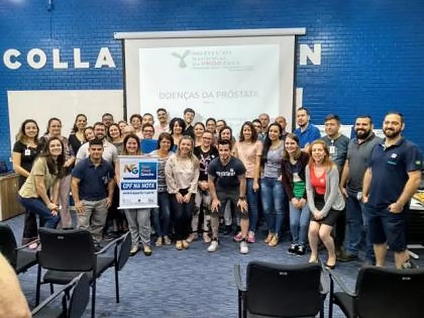 Grupo reunido diante da projeção “Doenças da Próstata”, com a marca do INPRÓS