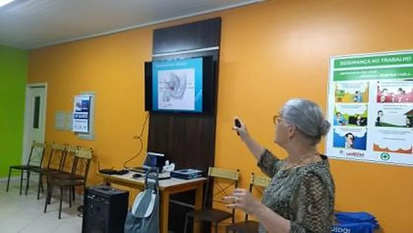 Palestrante aponta para a tela com uma ilustração da próstata em palestra do INPRÓS na Unifertil