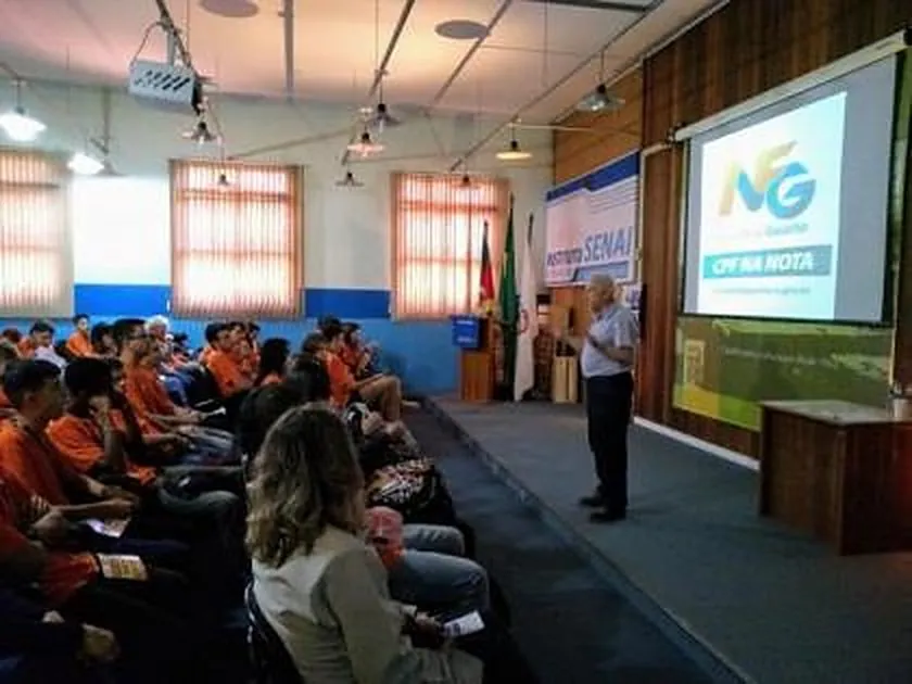 Palestrante apresenta a Nota Fiscal Gaúcha a jovens de uniforme laranja no Instituto SENAI